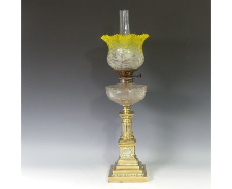 A brass squat column Oil Lamp, having a yellow etched frilled shade and clear glass font, raised upon a brass column and step