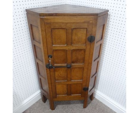 Robert Mouseman Thompson (1876-1955), an oak panelled floor standing Corner Cupboard, 1930's, &nbsp;the door with wrought iro