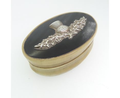 A Scottish 19thC oval horn Snuff Box, the lift off cover with an applied thistle motif,&nbsp;unmarked but tested as silver,&n