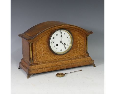 An early 20thC inlaid oak Mantle Clock, the central enamel dial flanked by gilt metal columns, with pendulum, on brass feet, 