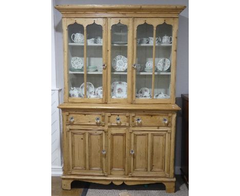 A Gothic Victorian pine glazed Kitchen Dresser, with double glazed doors enclosing two shelves, above a base with three friez