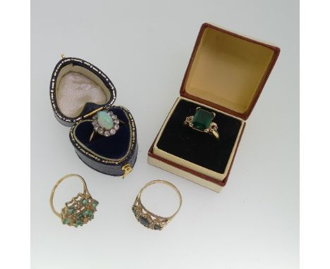 An emerald and diamond cluster Dress Ring, mounted in 9ct yellow gold, Size N, together with&nbsp; a three stone sapphire rin