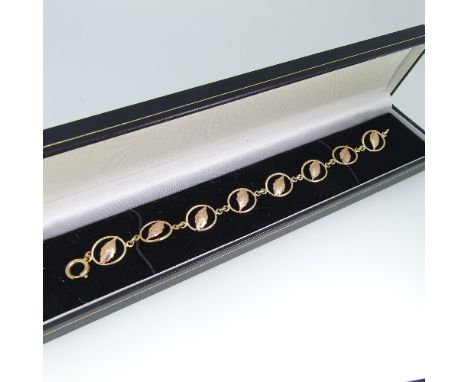 A 9ct gold Bracelet, formed of eight yellow gold open ovals, each with a rose gold leaf centre, bolt ring clasp, 19.5cm long,