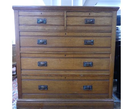 An Edwardian oak Chest of Drawers, comprising of two short over three long drawers with stylised loop handles, W 122cm x D 54