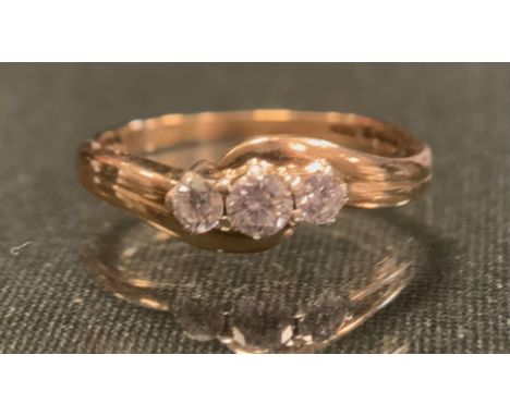 A diamond three stone ring, grooved and twisting top, set with three round brilliant cut diamonds, total estimated diamond we