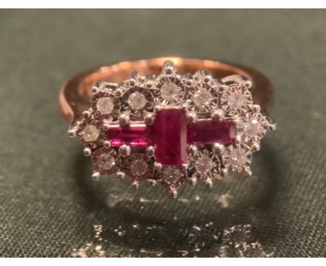 A ruby and diamond cluster ring, set with three baguette cut deep pinky red rubies, approx 0.71ct, surrounded by twelve round