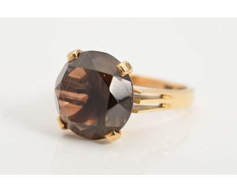 A SMOKY QUARTZ RING, designed as a circular smoky quartz in four claw setting to the abstract ring shank, stamped 14ct 585, a