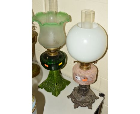A LATE VICTORIAN OIL LAMP, with green and opaque glass shade with wavy rim, green glass reservoir and green enamel metal base
