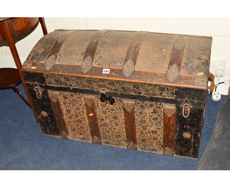 A 19TH CENTURY DOMED TOPPED TRUNK, wooden and metal bounded with foliate decoration and decoupage interior, width 87cm x dept