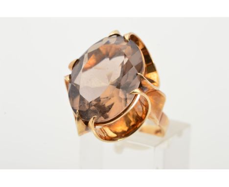 A 1970'S 9CT GOLD SMOKY QUARTZ RING, designed as an oval smoky quartz within a claw setting, the claws made of graduated semi