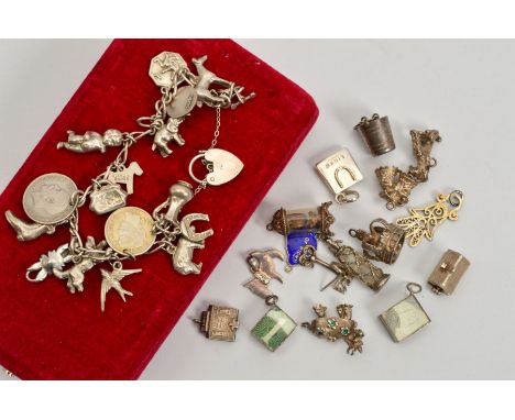 A CHARM BRACELET AND LOOSE CHARMS, the charm bracelet suspending a total of sixteen charms and a heart padlock clasp, togethe