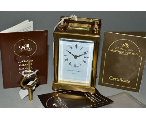 A MATTHEW NORMAN BRASS CASED CARRIAGE CLOCK, enamel dial with Roman numerals, five glazed panels, on bun feet, with key, heig