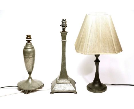 An Art Nouveau hammered pewter table lamp, the tapered ovoid body decorated with a beaded band, on a circular base raised ove