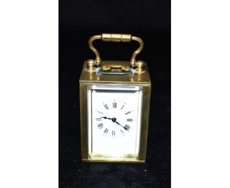 A MINATURE CARRIAGE CLOCK  the dial with Roman numerals, 6.5cm high with carrying handle down Condition Report : glass undama