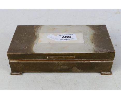 An Art Deco style silver cigarette box with cedar lined interior, engine turned decoration and raised on stepped supports, Lo