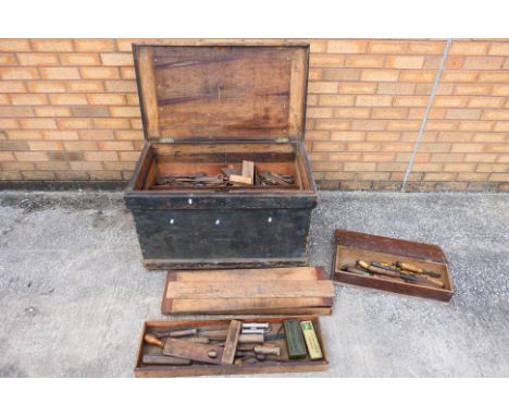 A Wooden tool chest containing vintage hand tools including chisels, drill bits, screwdrivers etc. Measuring 88cm (l) x 55cm 