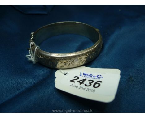 A hinged half engraved silver bangle (some denting) 24.8 gms