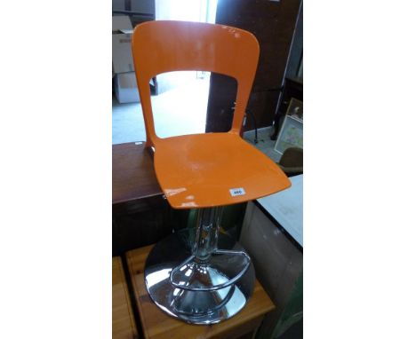 An orange plastic and chrome plated bar stool