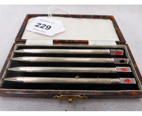 A cased set of four sterling silver propelling bridge pencils. Losses to card suit enamel motifs