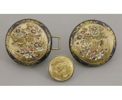 A pair of 'Satsuma' Buckles, circa 1900, of disc form, each painted with a bird amongst tall grasses and flowers, framed by b