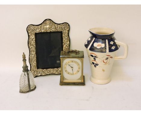 A modern silver photograph frame, a mantel clock, scent bottle, and a pottery jug