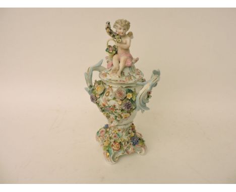 A 19th/20th century Sitzendorf porcelain urn and cover, the cover with a cherub holding a garland, the base with applied flow