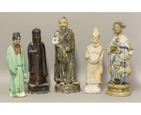 Five ceramic figures, mostly 19th century, two Guangdong stoneware of male and female immortals, a treacle-glazed Shou Lao, a