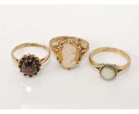 A 9ct gold garnet cluster ring, a gold single stone opal ring marked 9ct, and a 9ct gold shell cameo ring