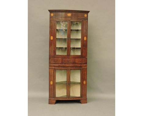 An early 19th century mahogany bow front free standing glazed corner cupboard, with inlaid shelf and patina decoration, 88cm 