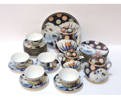 A Fukagawa porcelain tea set, each piece with carp and irises, on a blue vermiculated ground, five cups, ten saucers, nine pl