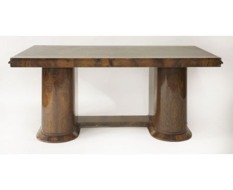 An Art Deco rosewood table, the rectangular top raised on two rounded pedestals united by a shelf on chamfered plinths, with 