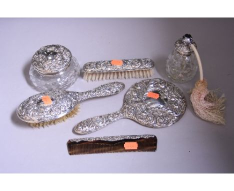 SILVER MOUNTED DRESSING TABLE BRUSHES, comb, mirror, atomiser and dressing table pot, all with embossed scroll, leaf and mask