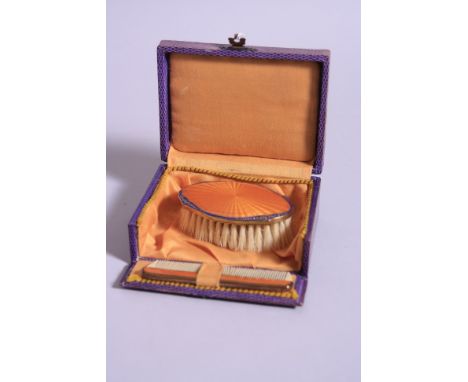 A CASED CHILD'S BRUSH AND COMB, having orange enamel mounts with cobalt blue and gilt border, case approximately 11.5cm x 9cm