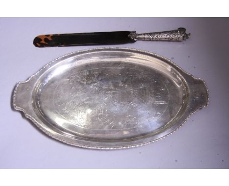 AN OVAL WHITE METAL TWIN HANDLED TRAY, with engraved tavern scene decoration to central panel and beaded rim, approximately 3