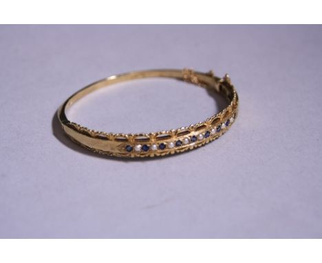 A 9CT GOLD SAPPHIRE AND PEARL BANGLE BRACELET, with scalloped border, diameter 5.5cm, hallmarks for London