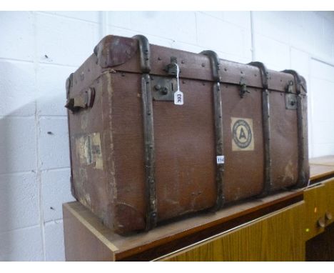 A VINTAGE WOODEN BOUND TRAVELLING TRUNK, with luggage labels