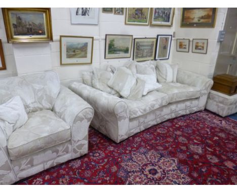 AN UPHOLSTERED THREE PIECE SUITE, comprising of a curved fronted three seater settee, an armchair and a pouffe