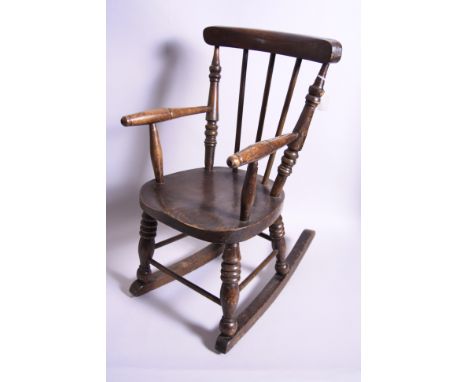 A CHILD'S ROCKING CHAIR, having stick back, turned arms and spindle supports, approximately 66cm high (glued and splits)