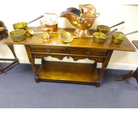 AN OAK TWO DRAWER SIDE TABLE, with drop leaf ends, shaped front apron, on turned supports and lower shelf, approximate extend