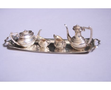 A MINIATURE SILVER TEA SERVICE AND TRAY, comprising half reeded teapot, sugar, milk jug, hot water and twin handled tray, Bir