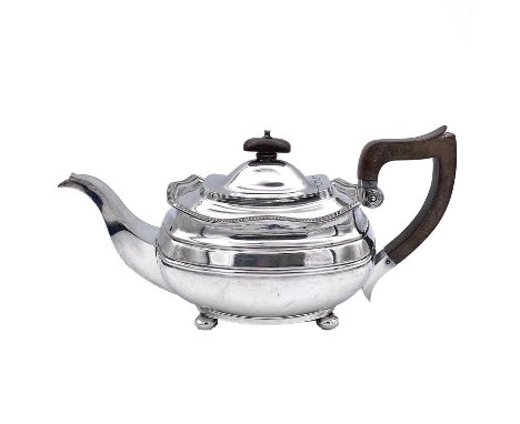 A silver plated teapot of oval section, with fruitwood handle and finial raised on ball feet, width 30cm.