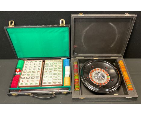 Games - a cased K &amp; C London roulette set with metal wheel, assorted chip counters;  cased and sealed Mah-Jong set (2) 