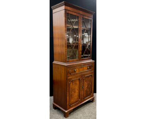 A George III style mahogany Secretaire bookcase, dentil cornice, astral-glazed doors enclosing two tiers of shelving, the bas