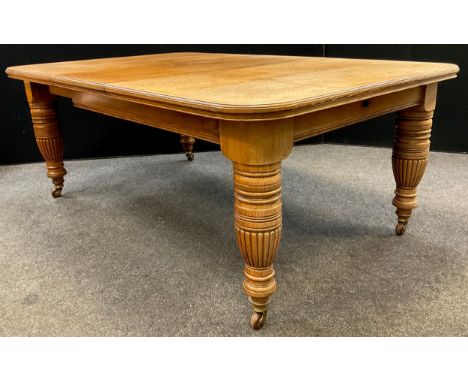 A Victorian oak extending dining table, rounded rectangular top, with single additional leaf, large turned, and reeded legs, 