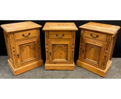 Three pine gothic style bedside cabinets, each with a single drawer to frieze, above a single cupboard door with carved Gothi