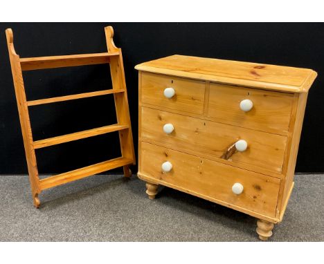 A pine chest of drawers, two short over two long drawers, ceramic handles, turned feet, 83cm high x 86.5cm wide x 45.5cm deep