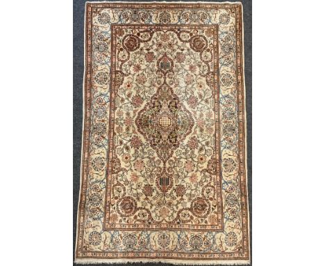 A Persian Kashan rug / carpet, wool and silk mix, knotted with Navette-shaped medallion, within a field of stylised flowering