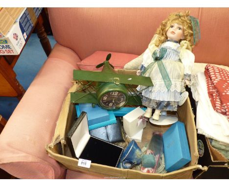 A box of miscellaneous to include: a china doll, an aeroplane clock, empty jewellery boxes, etc.
