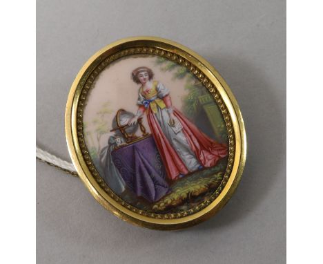 A 9ct gold mounted oval portrait miniature of a lady by a globe, 1.5in.