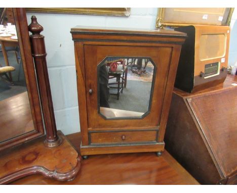 A Victorian table top miniature apprentice piece wardrobe, the mirrored door opening to reveal shelf space, over single drawe